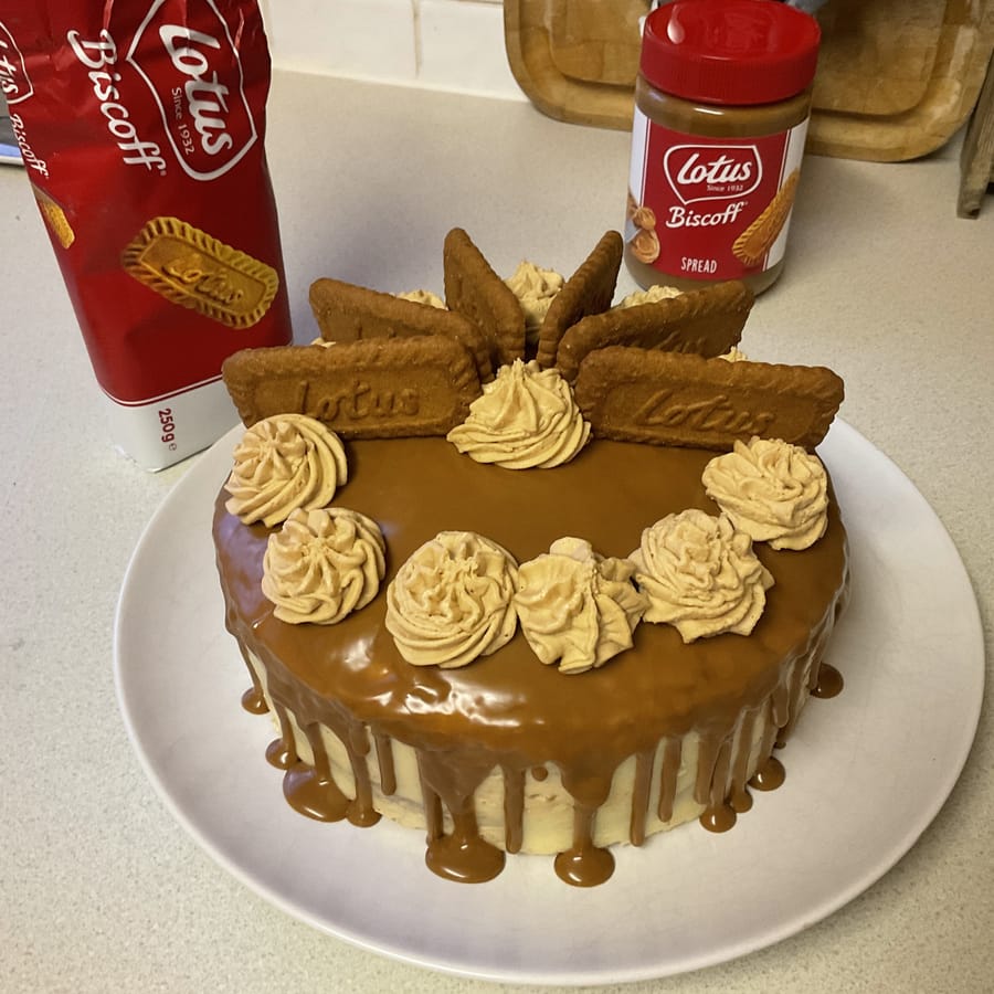 A Lotus Biscoff caramel-drip cake piped with buttercream rosettes and topped with Biscoff biscuits