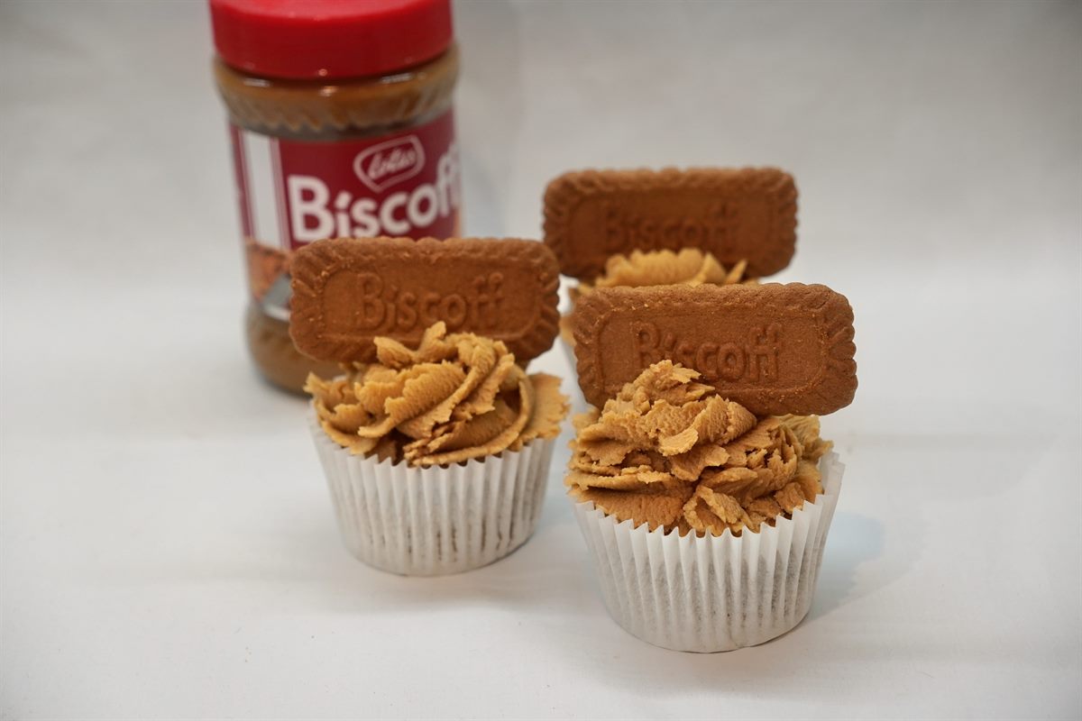 Three Biscoff cupcakes piped with Biscoff buttercream, each topped with a Lotus Biscoff biscuit